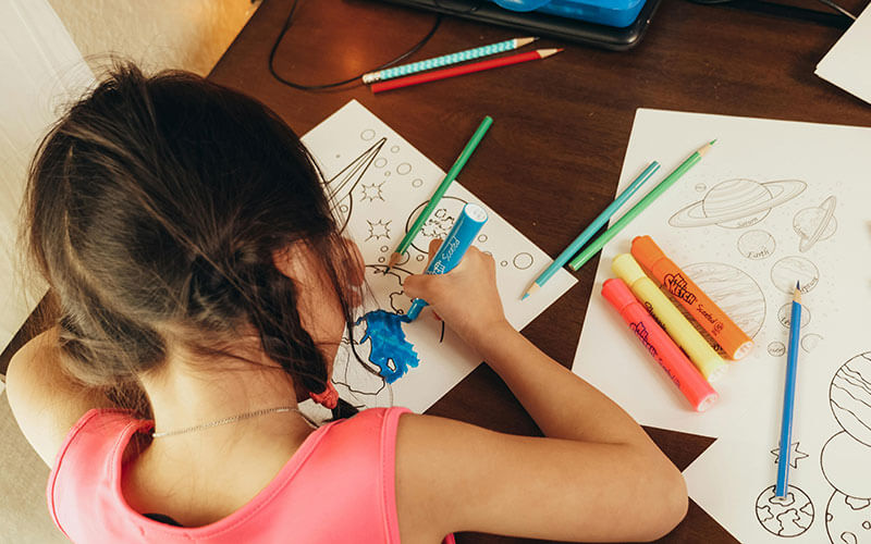 Child using school supplies during an educational activity provided through a community-focused nonprofit program.