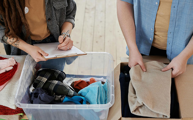 Volunteers sorting and organizing donated clothing for a nonprofit thrift and social enterprise supporting community programs.